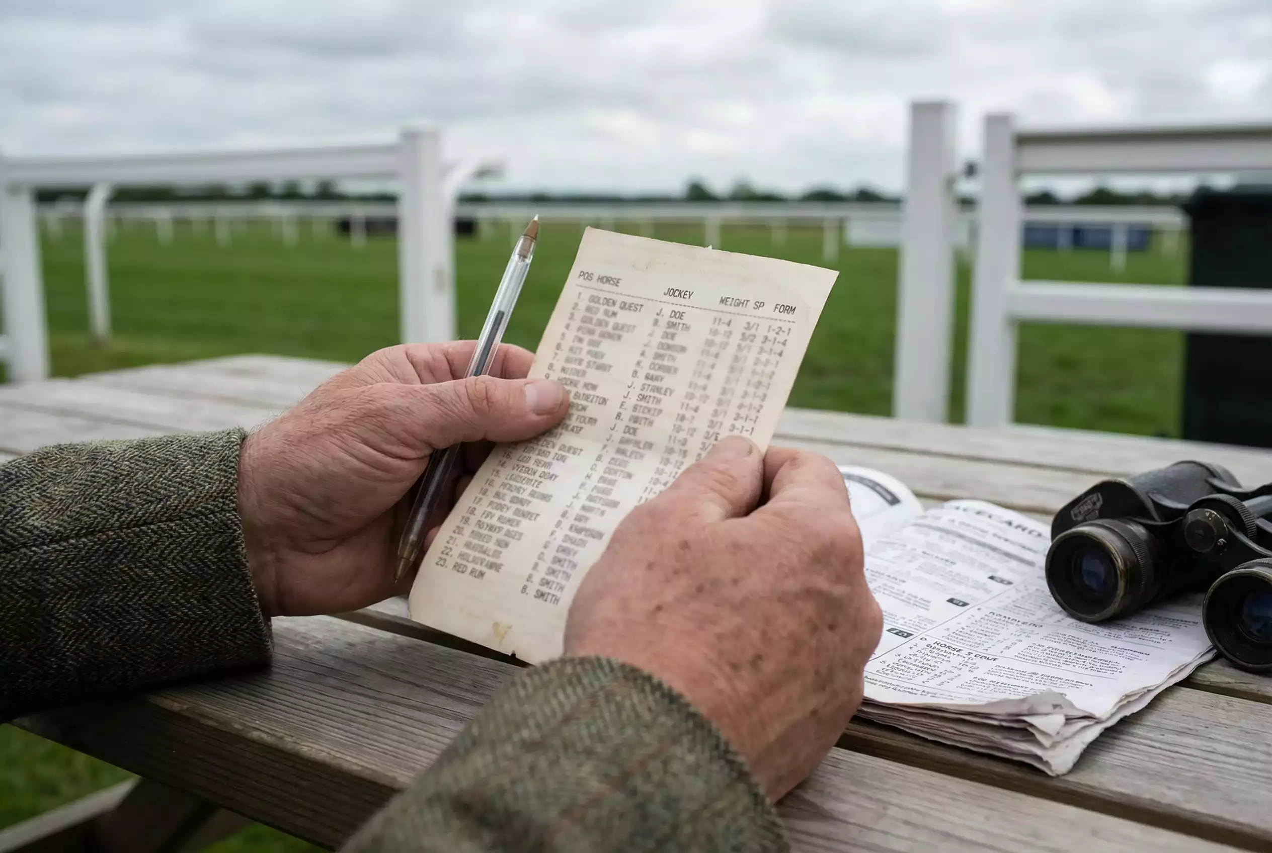 Close-up of a printed horse racing result card with finishing positions, jockey names and starting prices at a British racecourse