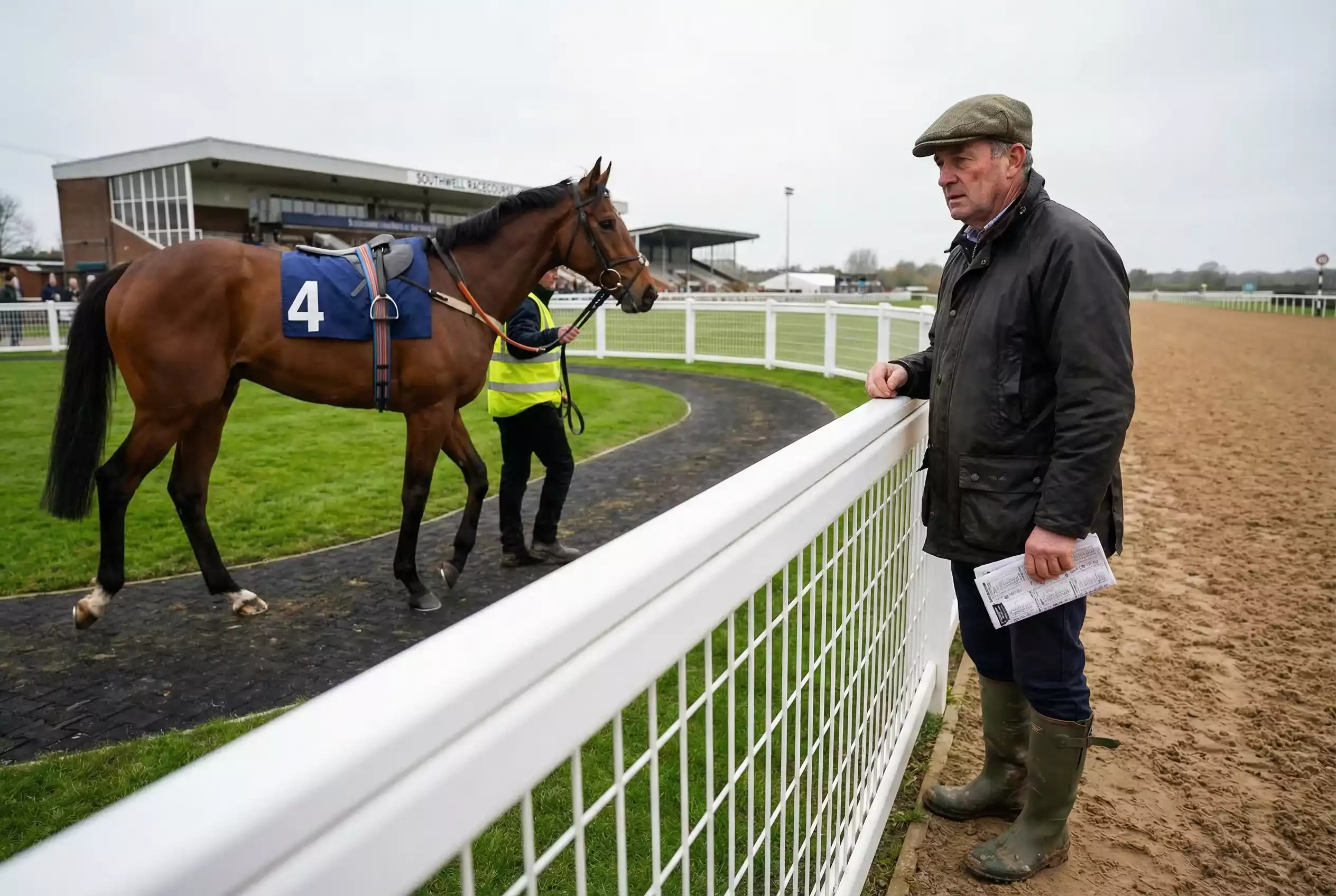 Trainer watching a racehorse in the parade ring at Southwell Racecourse before an all-weather fixture